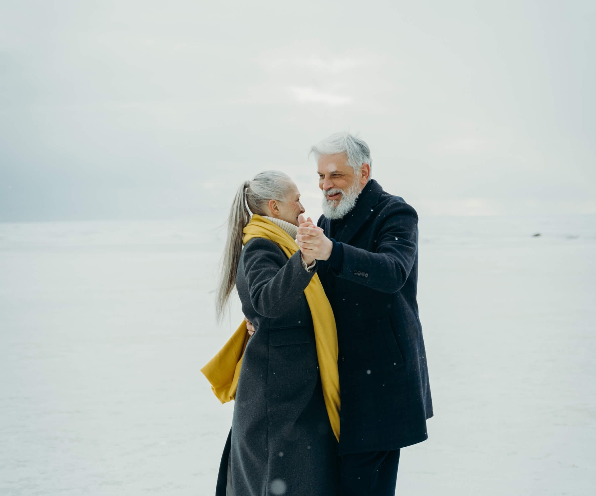 Elderly couple dancing on snow-covered ground