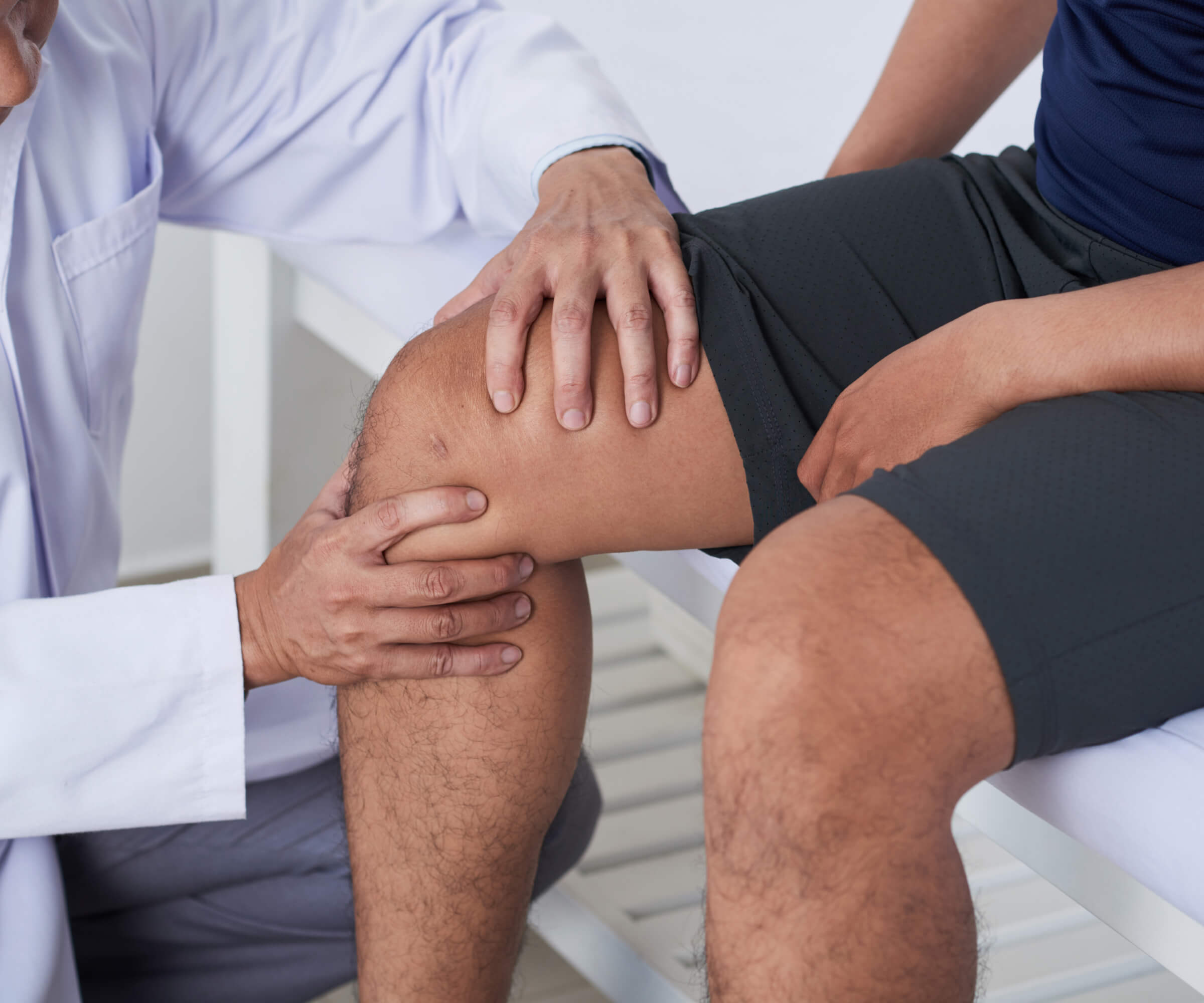 Provider performing diagnostic knee exam on patient